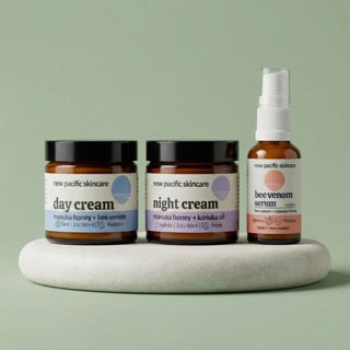 Shop All New Pacific Skincare: A complete set of clinical night creams and treatments formulated with Manuka honey, Kanuka oil, and Vitamin C, displayed on a stone surface with a clean green backdrop.