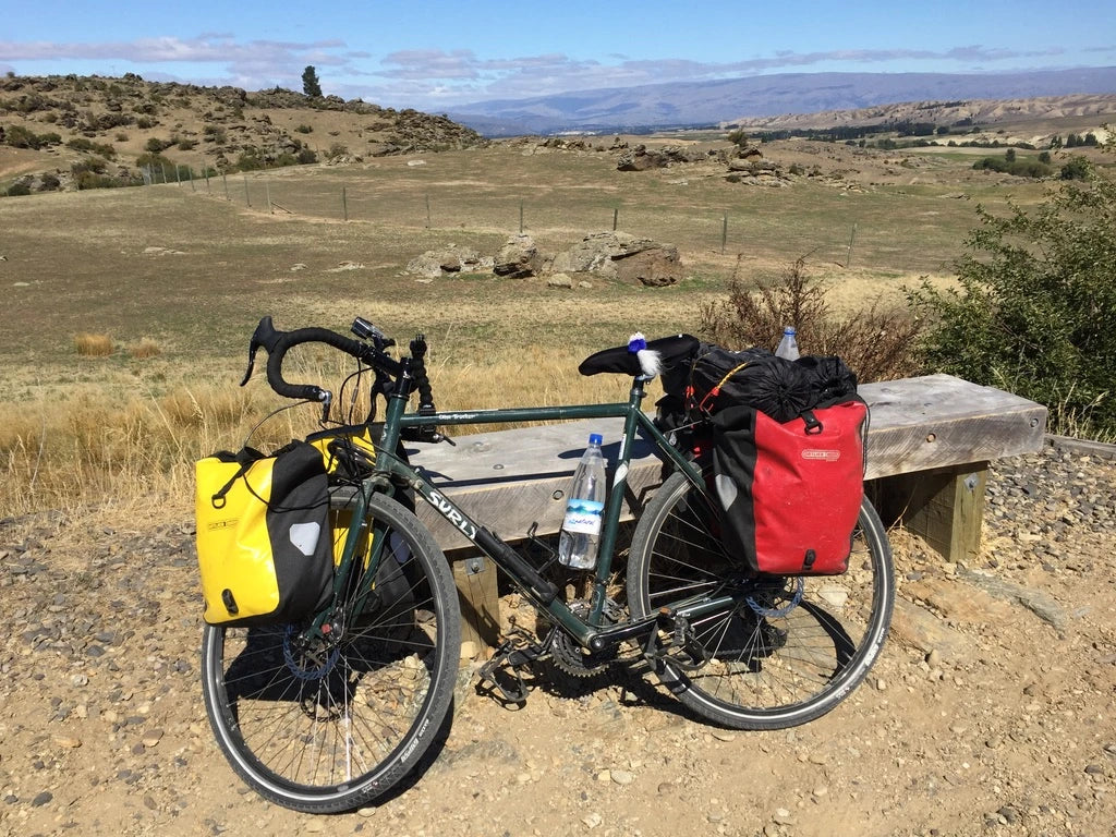 A bike in central otago new zealand loaded with panniers and a tent. 